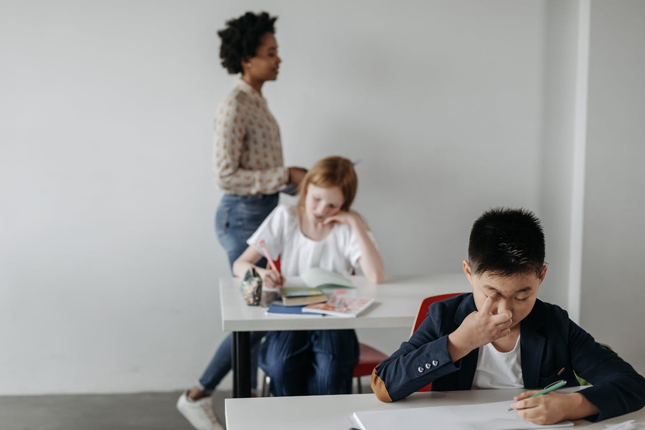Focused classroom scene with students studying under teacher supervision.